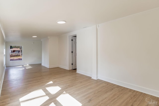 unfurnished room featuring crown molding and light hardwood / wood-style floors