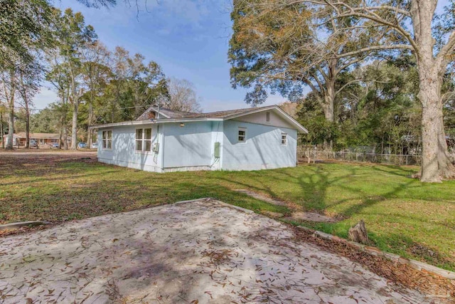 rear view of house with a patio and a lawn