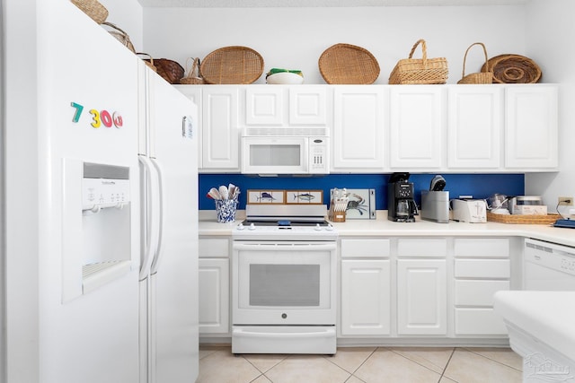 kitchen with light tile patterned floors, white cabinets, and white appliances