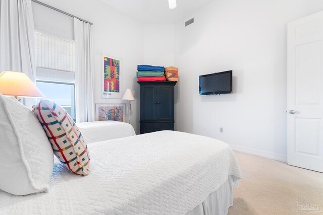 bedroom with light colored carpet and multiple windows