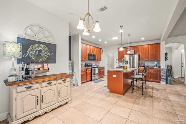 5409 Dalton Cir, Milton, FL 32570 - kitchen featuring stainless steel appliances, arched walkways, a chandelier, a breakfast bar, and an island with sink
