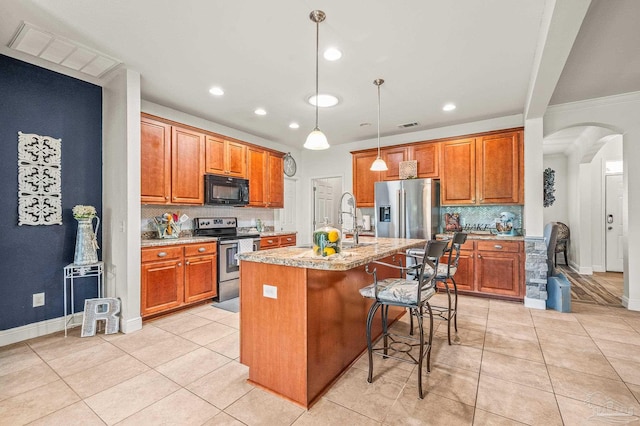 5409 Dalton Cir, Milton, FL 32570 - kitchen with appliances with stainless steel finishes, arched walkways, brown cabinets, backsplash, and recessed lighting