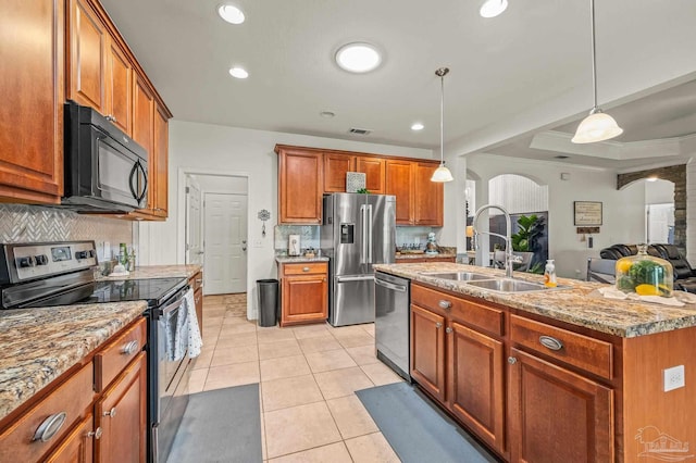 5409 Dalton Cir, Milton, FL 32570 - kitchen featuring appliances with stainless steel finishes, arched walkways, backsplash, hanging light fixtures, and light tile patterned flooring