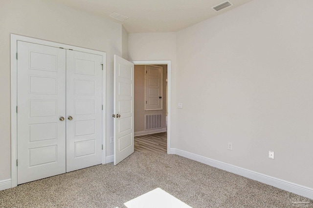 unfurnished bedroom featuring a closet, carpet flooring, visible vents, and baseboards