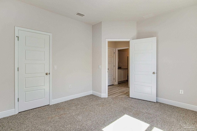 unfurnished bedroom featuring carpet, visible vents, and baseboards