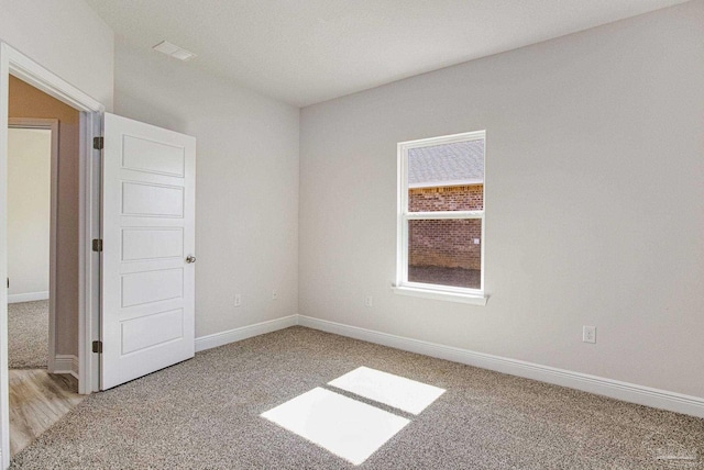 unfurnished room with light colored carpet and baseboards