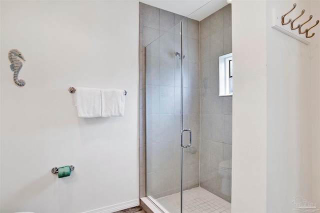 bathroom featuring toilet and a shower with shower door