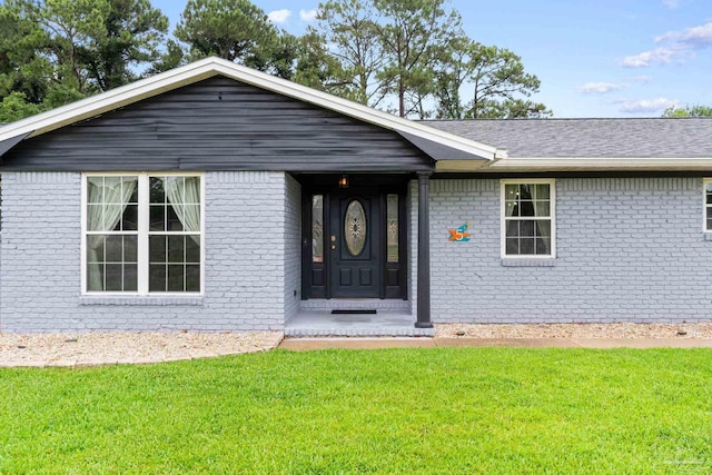 view of front of home with brick siding and a front yard