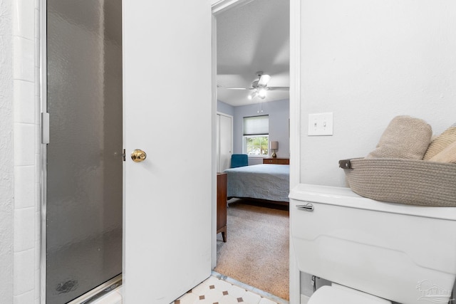 ensuite bathroom featuring tile patterned floors, connected bathroom, a ceiling fan, and a shower stall