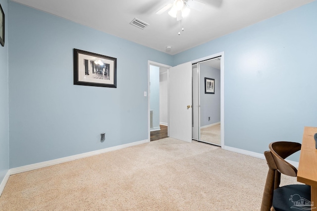 unfurnished office with baseboards, a ceiling fan, visible vents, and light colored carpet