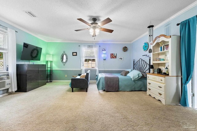 carpeted bedroom featuring a ceiling fan, a textured ceiling, visible vents, and crown molding