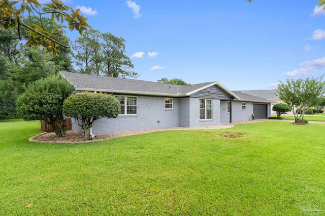 view of front facade with brick siding, a shingled roof, concrete driveway, an attached garage, and a front yard