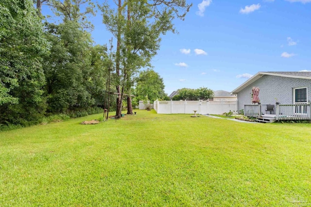 view of yard featuring a wooden deck and fence