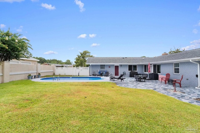 back of property with a fenced in pool, brick siding, a yard, a patio area, and a fenced backyard