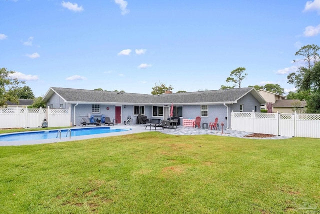 back of property featuring a fenced backyard, a fenced in pool, a lawn, and a patio