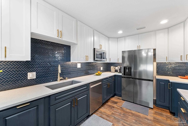 kitchen with stainless steel appliances, a sink, and light countertops