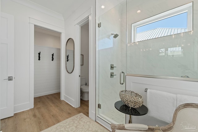 full bathroom with a shower stall, toilet, and wood finished floors