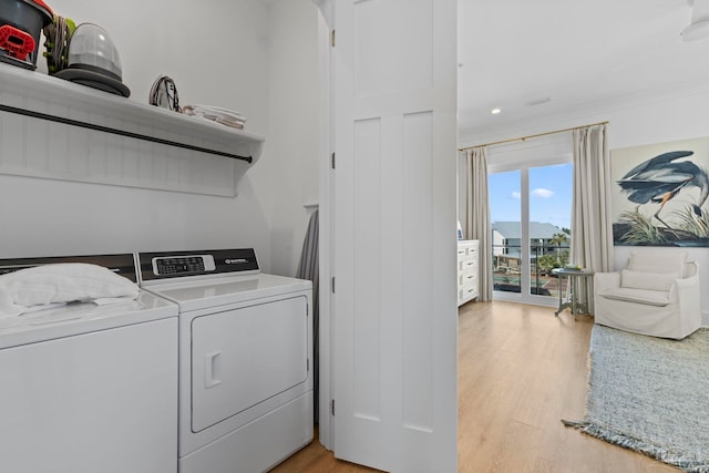 clothes washing area featuring washing machine and dryer, laundry area, and light wood finished floors