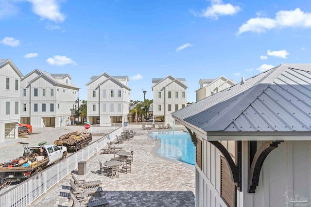 community pool with a patio area and fence