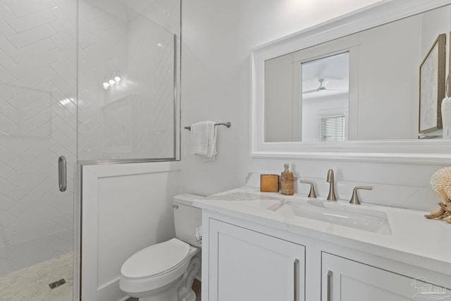 bathroom featuring vanity, toilet, and a stall shower