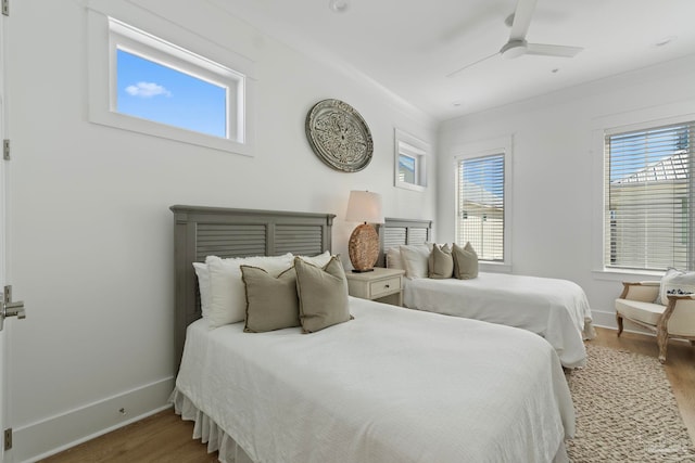 bedroom with a ceiling fan, baseboards, and wood finished floors