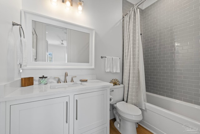 bathroom with vanity, shower / tub combo, and toilet