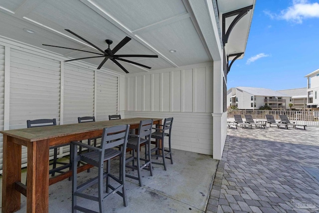 view of patio / terrace featuring outdoor dry bar, a residential view, ceiling fan, and fence