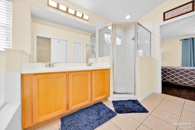 bathroom featuring a shower with door, vanity, and tile patterned flooring