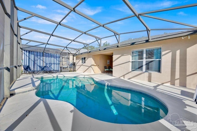 view of swimming pool with a patio and a lanai