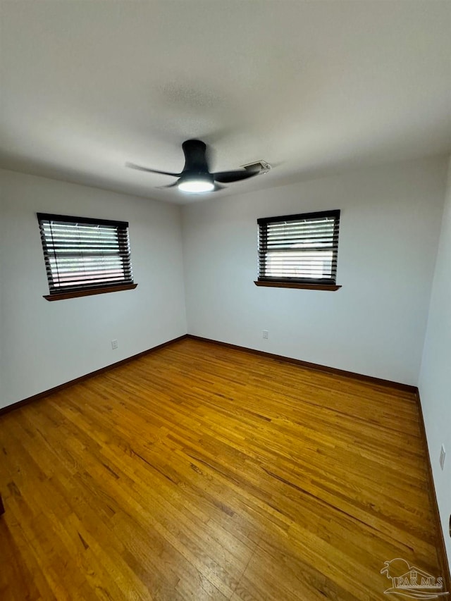 spare room featuring hardwood / wood-style flooring, plenty of natural light, and ceiling fan