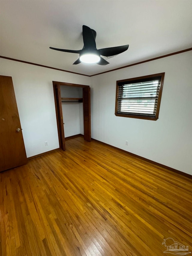 unfurnished bedroom with hardwood / wood-style flooring, a closet, and ceiling fan