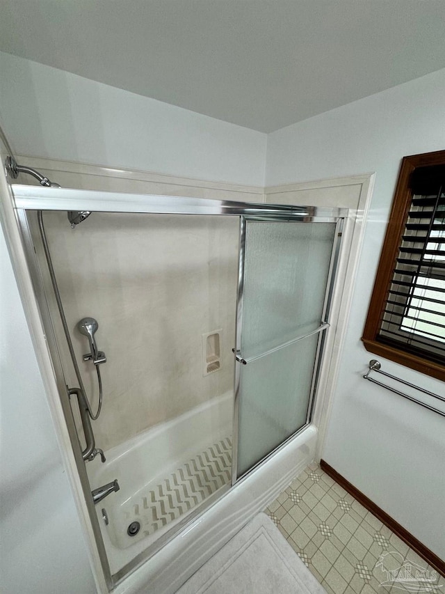 bathroom with combined bath / shower with glass door