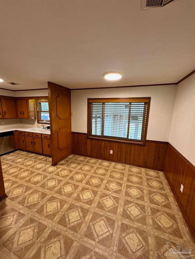 kitchen with crown molding, sink, plenty of natural light, and wooden walls