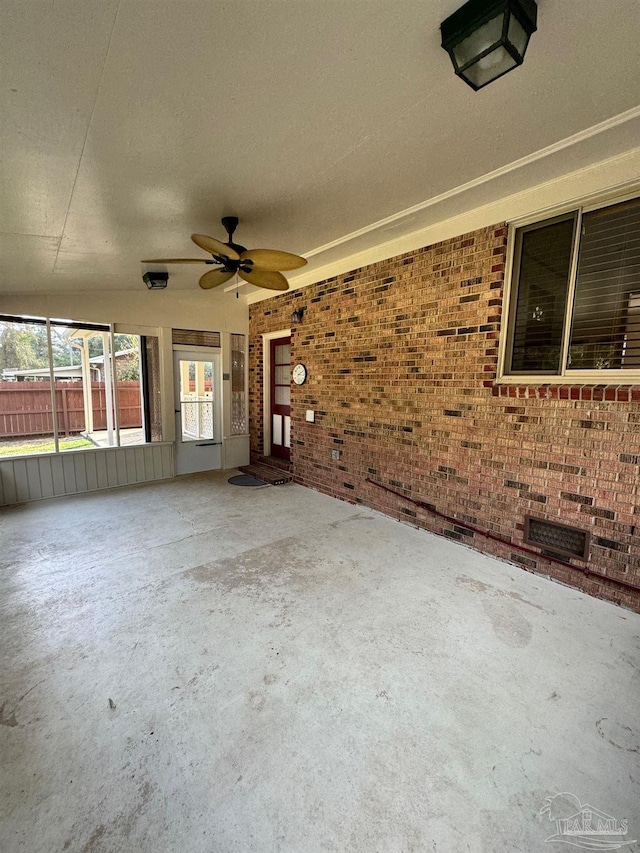 unfurnished sunroom featuring ceiling fan