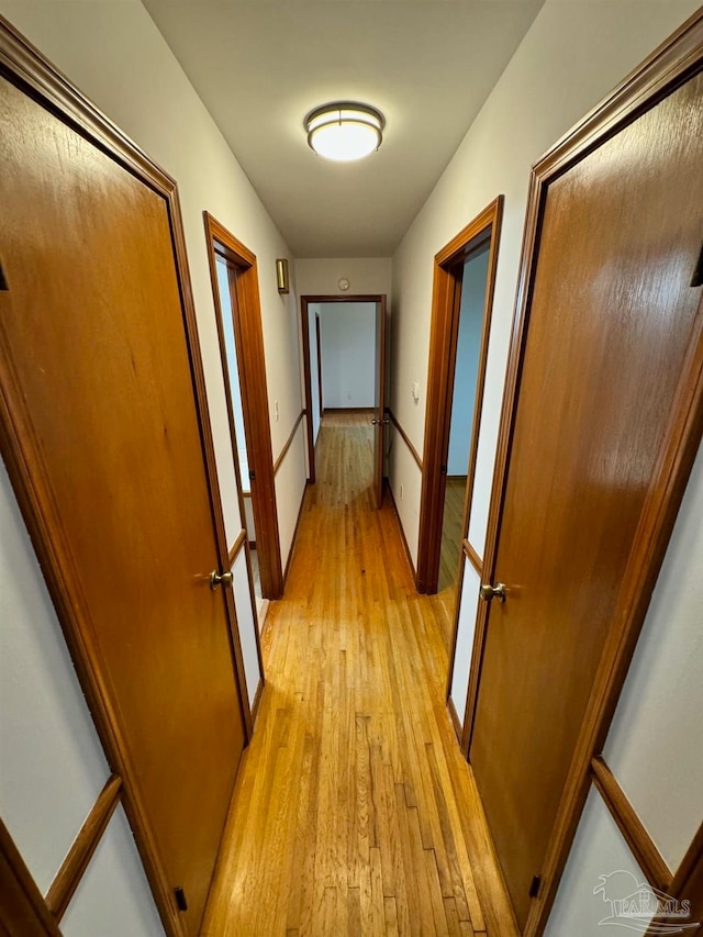 hallway with light hardwood / wood-style floors