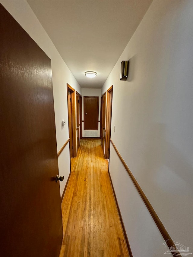 hallway with light hardwood / wood-style floors