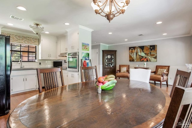 6031 Keating Rd, Pensacola, FL 32504 - dining room with a chandelier, ornamental molding, recessed lighting, and light wood-type flooring