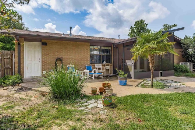 6031 Keating Rd, Pensacola, FL 32504 - back of house with a sunroom, a patio, and brick siding