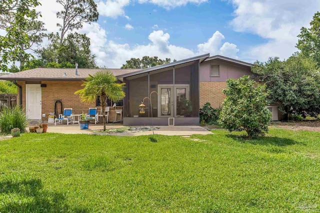 6031 Keating Rd, Pensacola, FL 32504 - back of property with brick siding, a sunroom, a lawn, and a patio area