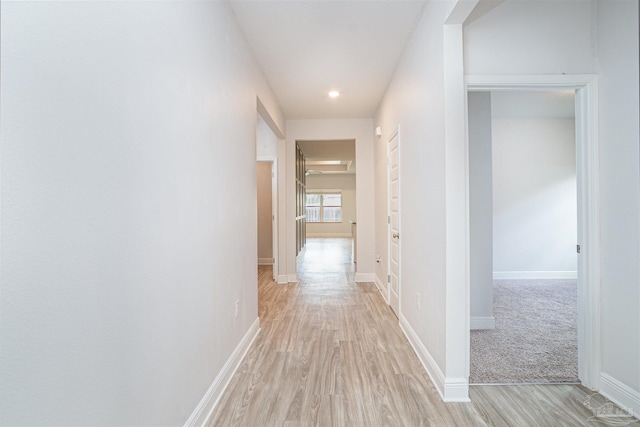 hall with light wood-type flooring, recessed lighting, and baseboards