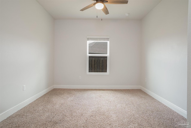 carpeted spare room featuring baseboards and ceiling fan