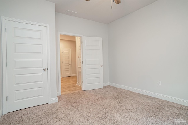 unfurnished bedroom featuring baseboards, visible vents, and light carpet