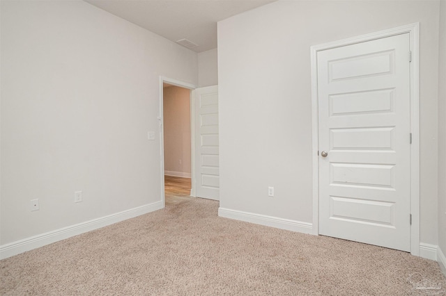 unfurnished room featuring carpet floors and baseboards