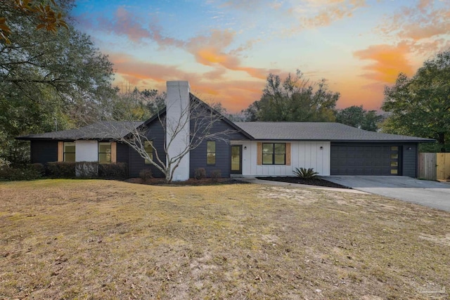 view of front of house with a garage and a lawn