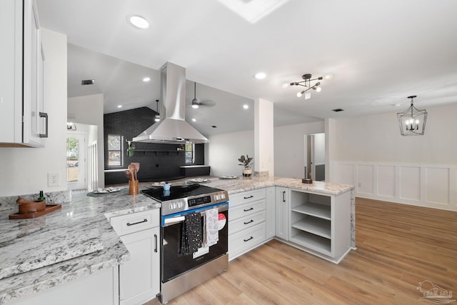 kitchen with white cabinetry, stainless steel electric range, island range hood, and kitchen peninsula