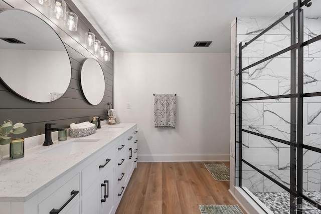 bathroom with wood walls, vanity, hardwood / wood-style floors, and a shower