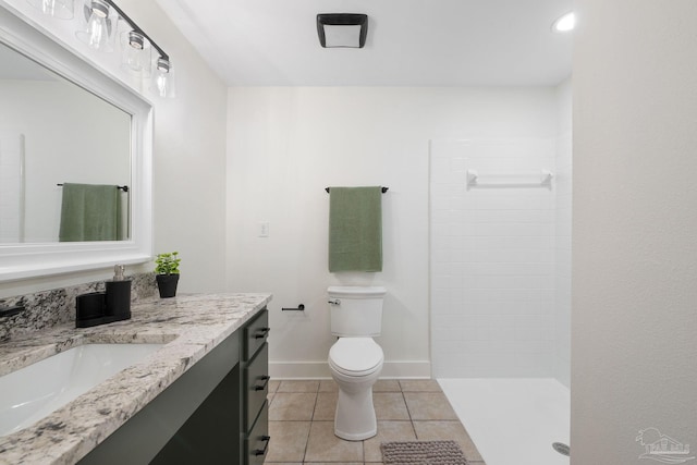 bathroom with tile patterned flooring, vanity, toilet, and walk in shower