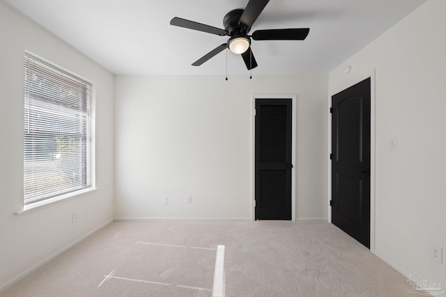 spare room with light colored carpet and ceiling fan