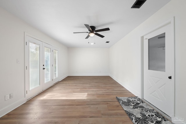 spare room with french doors, ceiling fan, and light hardwood / wood-style flooring