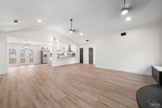 unfurnished living room featuring vaulted ceiling, ceiling fan, and light wood-type flooring